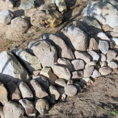 Isojen kivien tausta tuettu keskikokoisilla kivillä.
