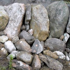 Kivien välit tilkitty litteillä kivillä. Taustan alaosa tuettu.